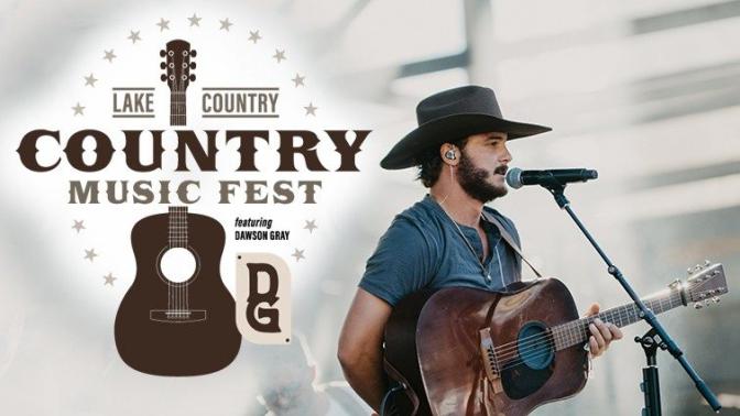 Country artist Dawson Gray signing at a microphone holding a guitar