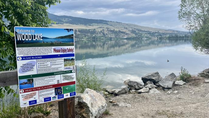 A sign posted at an entrance to a beach that signals there is an algae bloom in Wood Lake