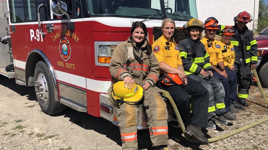 firefighters sitting on front of truck resting