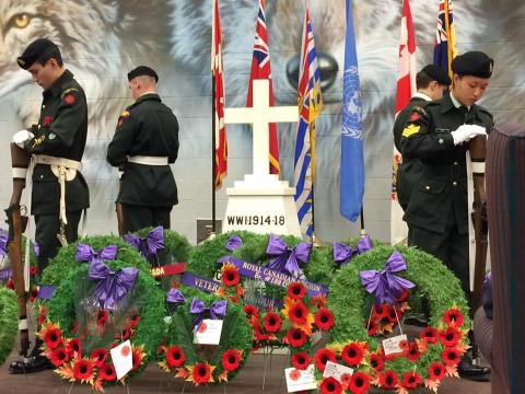 cadets stand around Remembrance Day memorial with wreaths