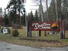 Jack Seaton Park sign with trees and a walking path in the background.